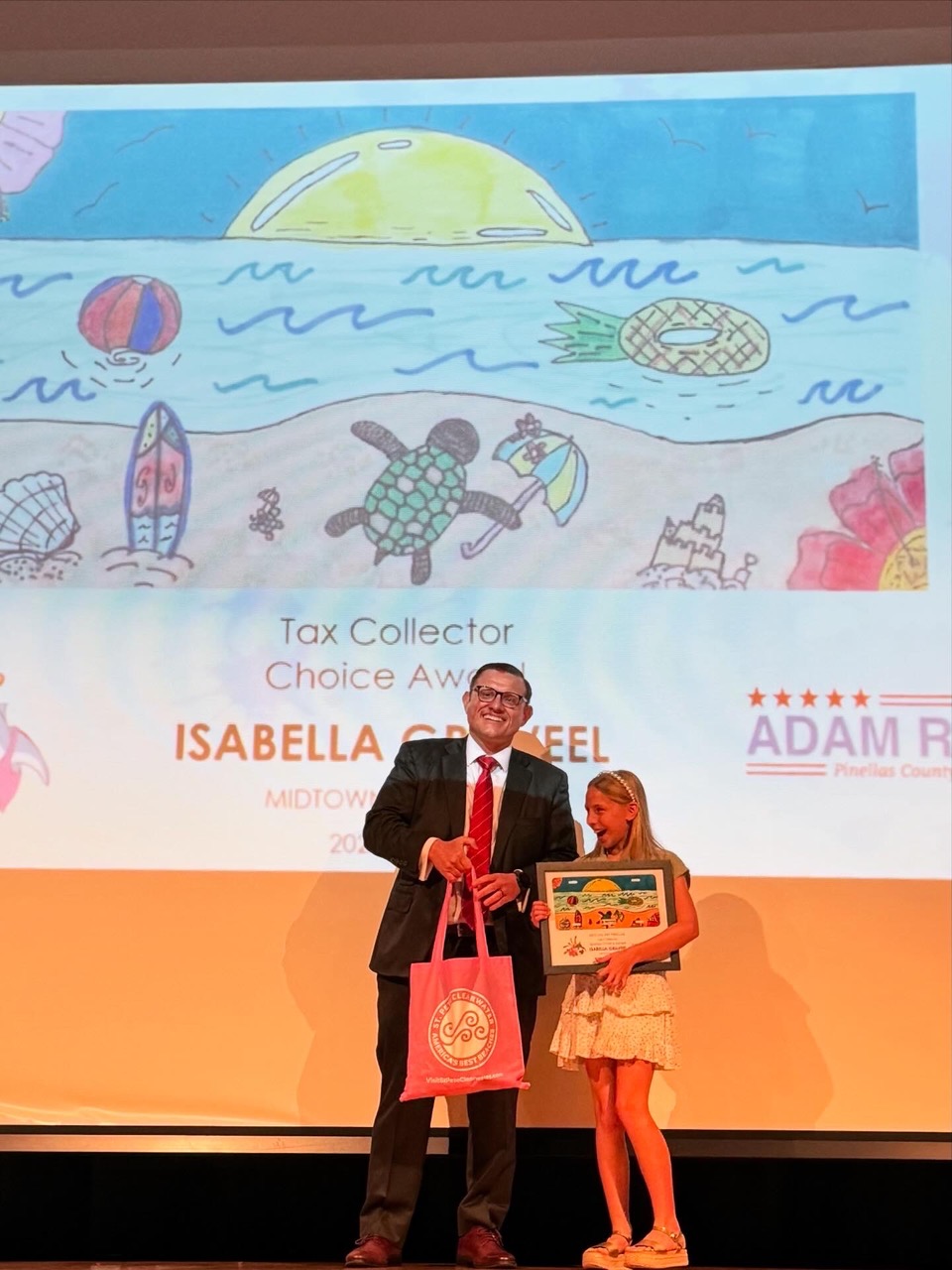 Tax Collector Adam Ross presents his award to Isabella G